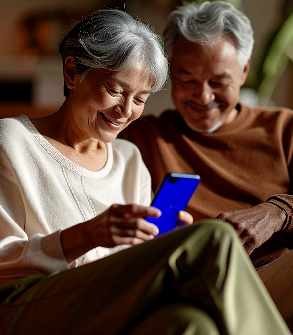 Imagem com um casal de senhores olhando para um celular azul